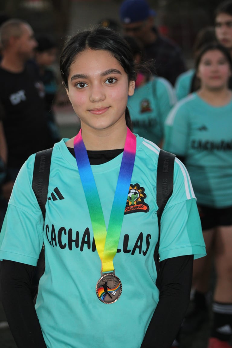 Young athlete wearing a turquoise sports jersey and a rainbow medal at a competition event