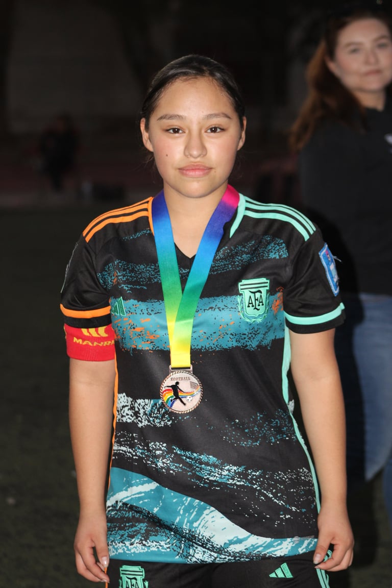 Young athlete wearing Argentina sports jersey displaying a medal around her neck