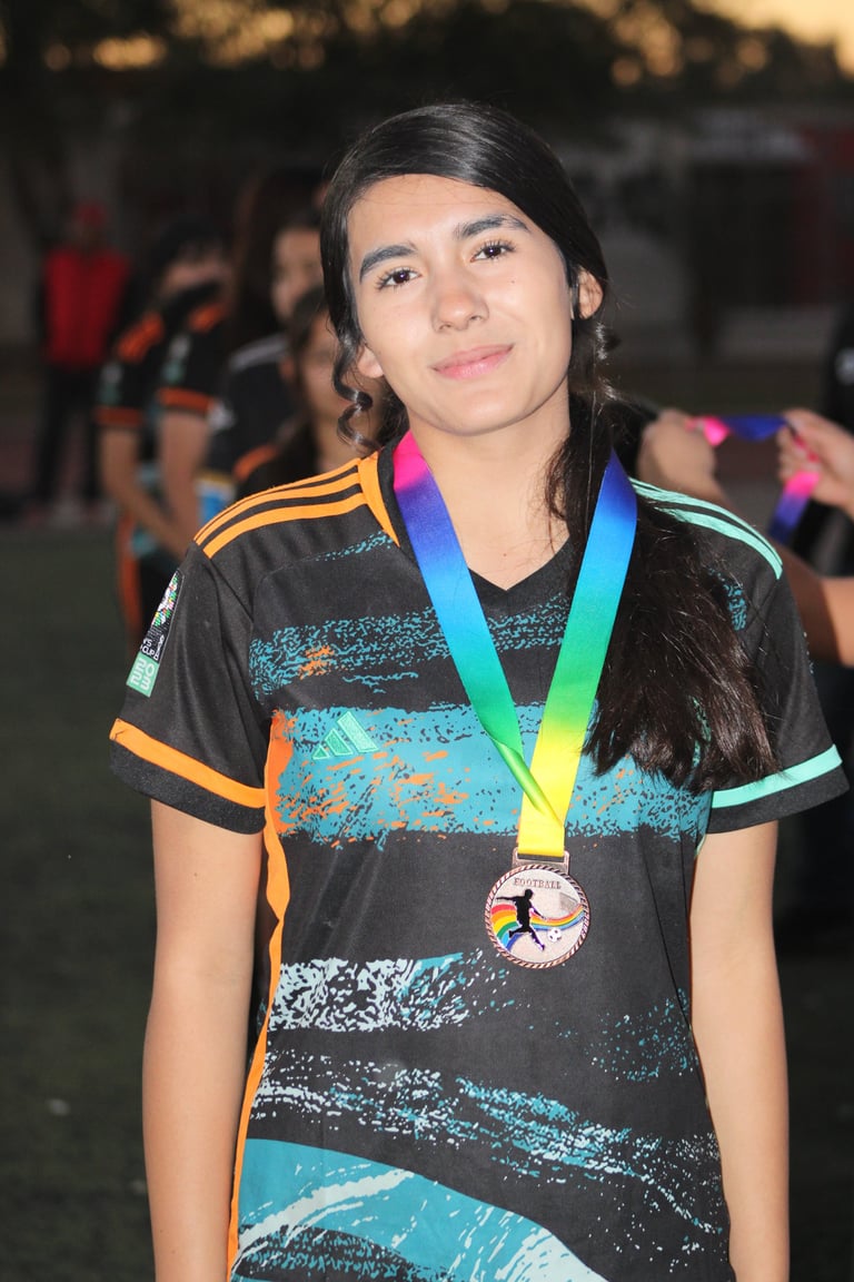 Young athlete wearing colorful sports jersey and rainbow medal around neck at outdoor event
