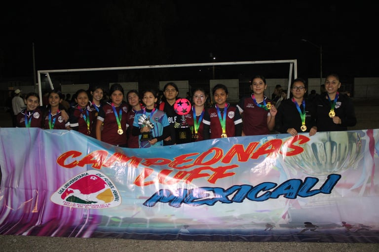 Group of young athletes posing behind a colorful Champion banner at night