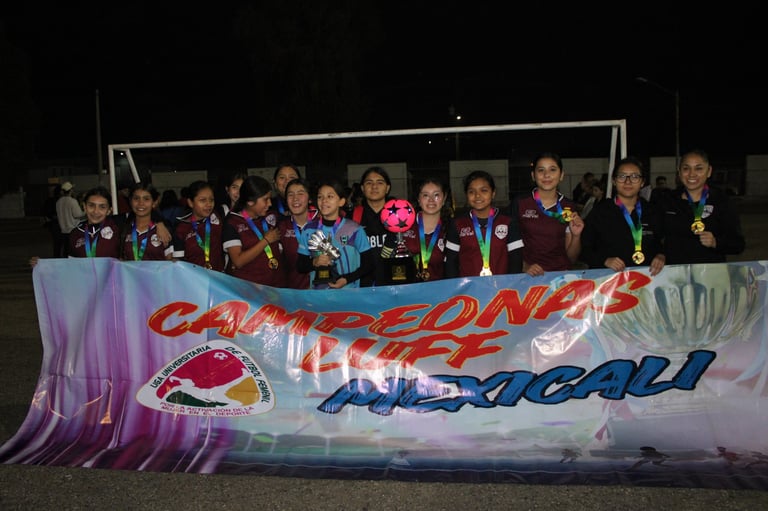 Group of young athletes posing together behind a colorful banner at what appears to be a swimming or aquatic sports competition event