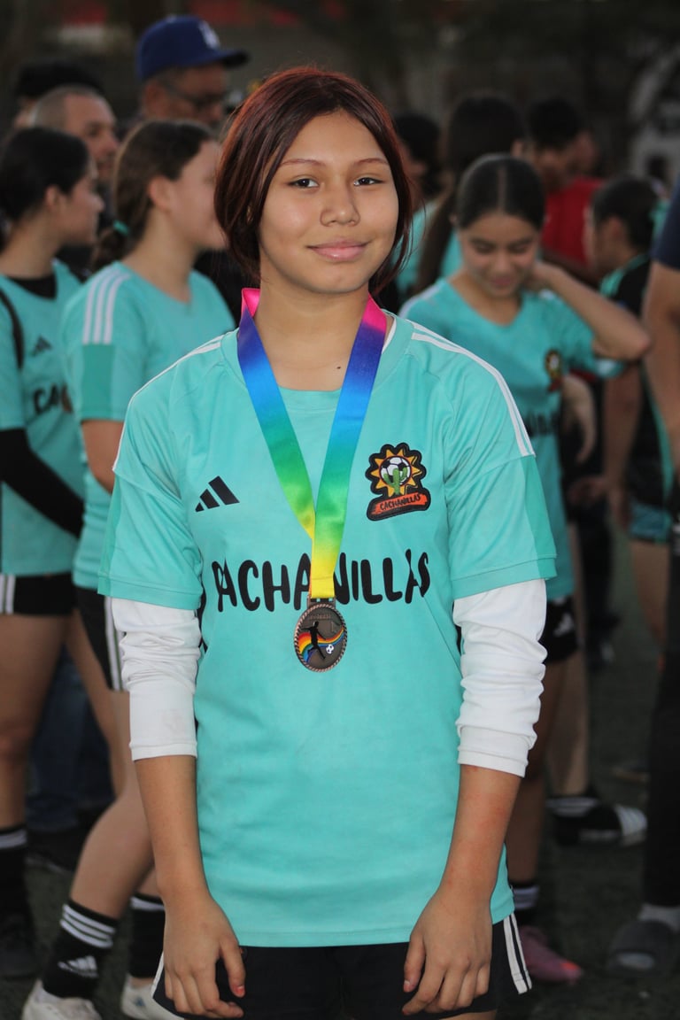 Young athlete wearing turquoise Acapulco team jersey with medal around neck, surrounded by teammates in background