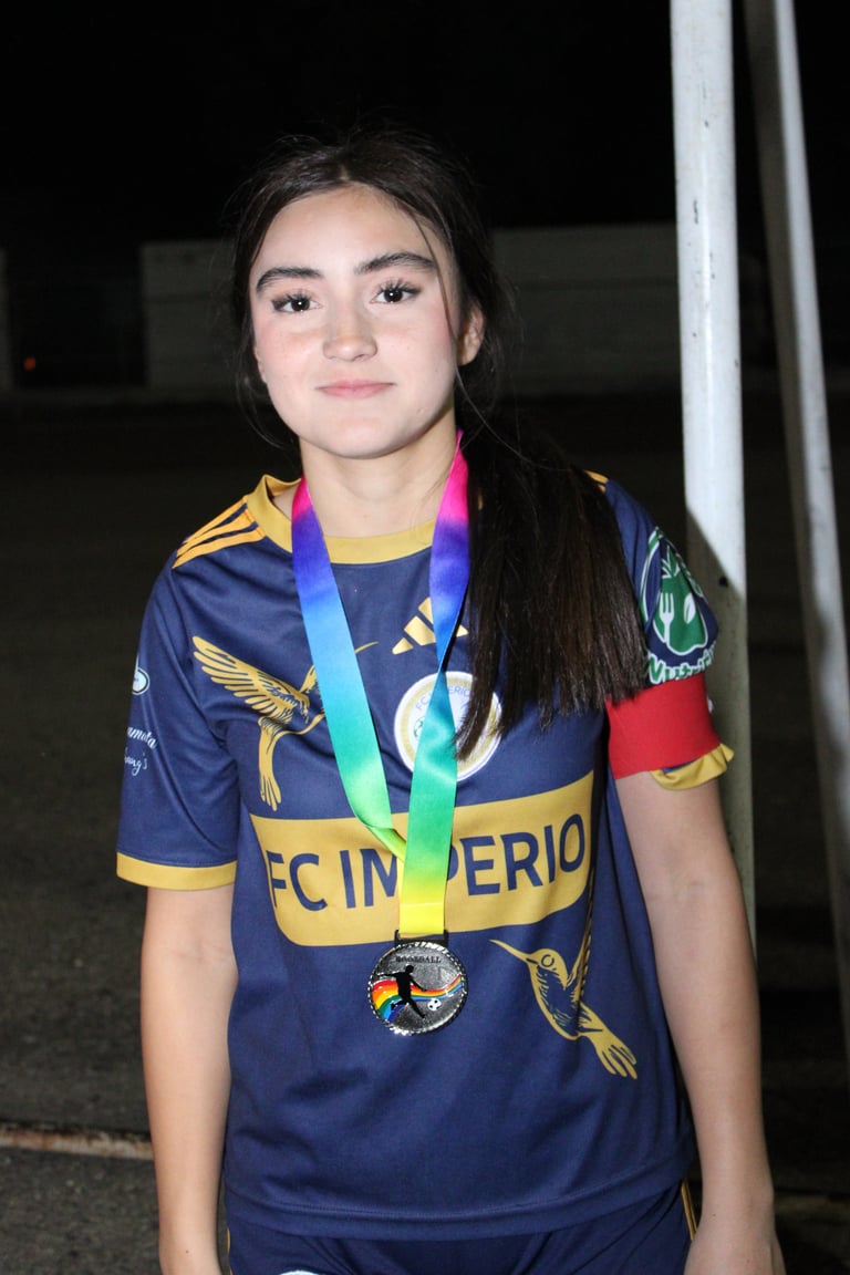 Young athlete wearing navy sports jersey with yellow accents, displaying a rainbow medal around her neck