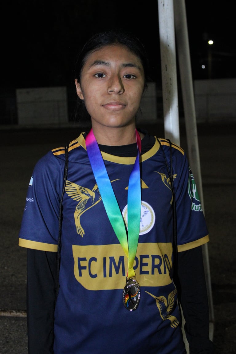 Young athlete wearing navy and gold FC Imperia sports jersey displaying a rainbow medal around neck