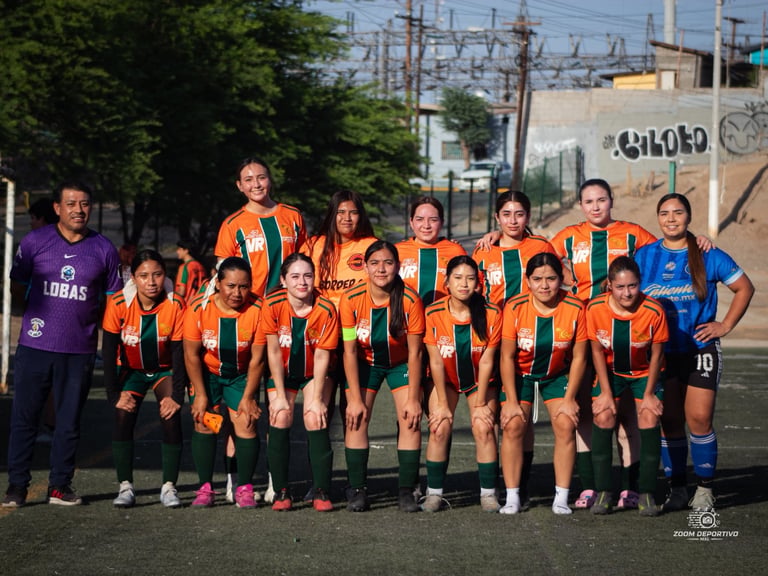 Youth soccer team in orange and black striped uniforms posing for a group photo on a field