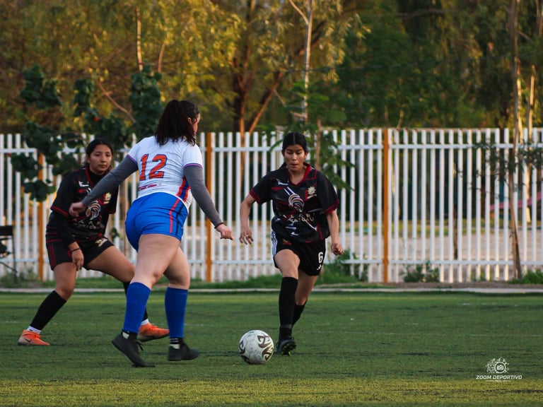 Soccer match with female player in white and blue uniform controlling ball while two players in dark jerseys defend